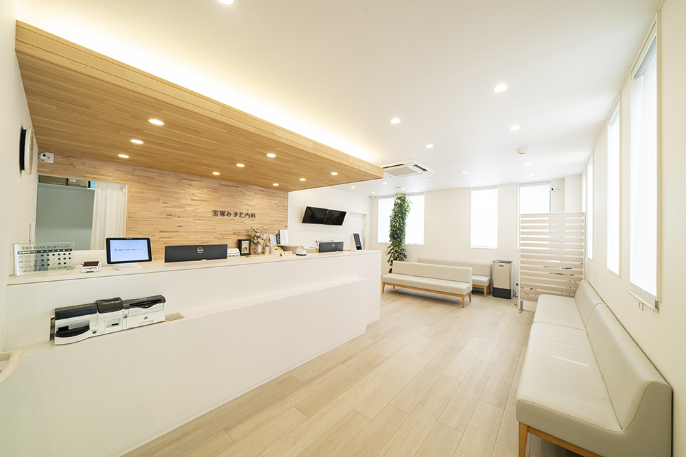 待合室: 大きな窓から自然光が差し込む、明るく開放的な空間です。ゆったりと座れる長椅子をご用意しました。